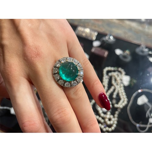 88 - A striking cabochon emerald and diamond cluster ring, circa 1950The central ovoid-shaped cabochon em... 