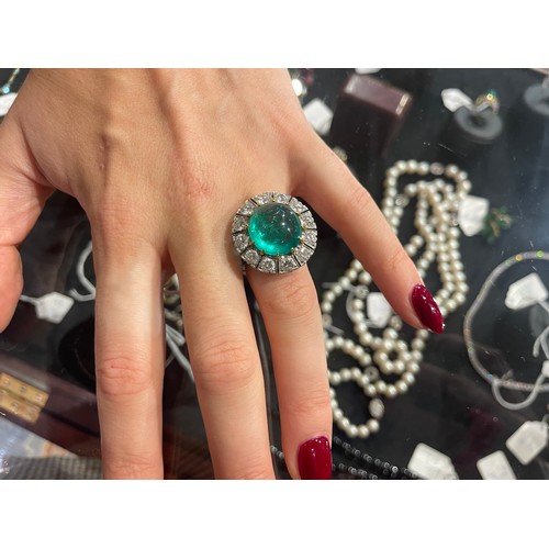 88 - A striking cabochon emerald and diamond cluster ring, circa 1950The central ovoid-shaped cabochon em... 