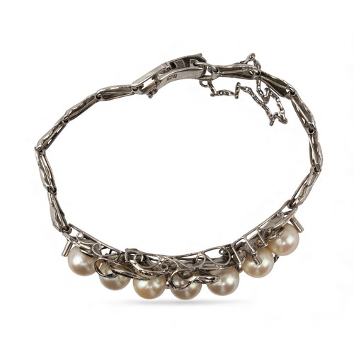 48 - A white gold and cultured pearl bracelet, circa 1950The front set with seven uniform-sized 7.1 mm. c... 