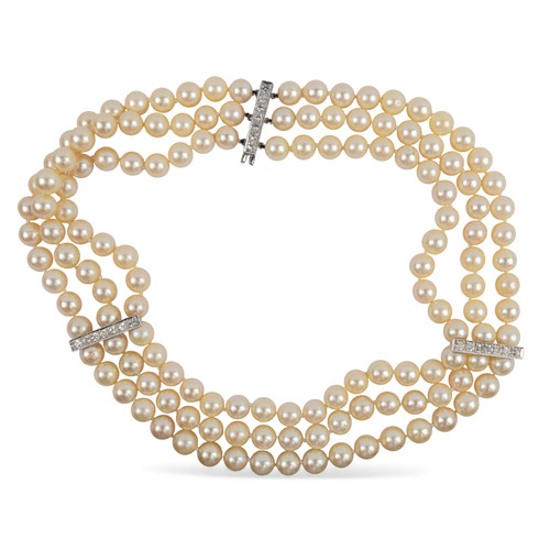 46 - A three-row cultured pearl necklaceComposed of 9.5 mm. uniform-sized bead. With white sapphire and s... 