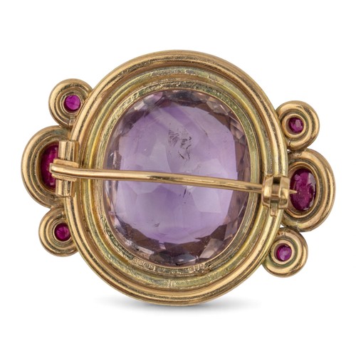 51 - Circa 1990sAn amethyst, gold and ruby broochSet to the centre with a large oval mixed cut amethystWi... 