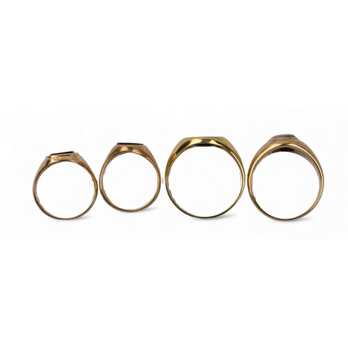 21 - A group of four various sized onyx and gold signet ringsTotal weight: Approx. 12.5 g.