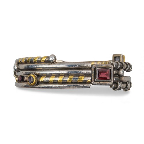 42 - Barbara BertagnolliA most unusual silver, gold and gem-set bangle. Set with multicoloured gemstones ... 