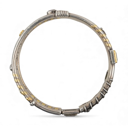 42 - Barbara BertagnolliA most unusual silver, gold and gem-set bangle. Set with multicoloured gemstones ... 