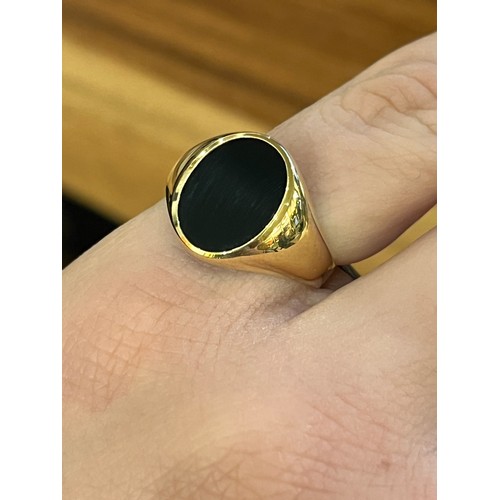 21 - A group of four various sized onyx and gold signet ringsTotal weight: Approx. 12.5 g.
