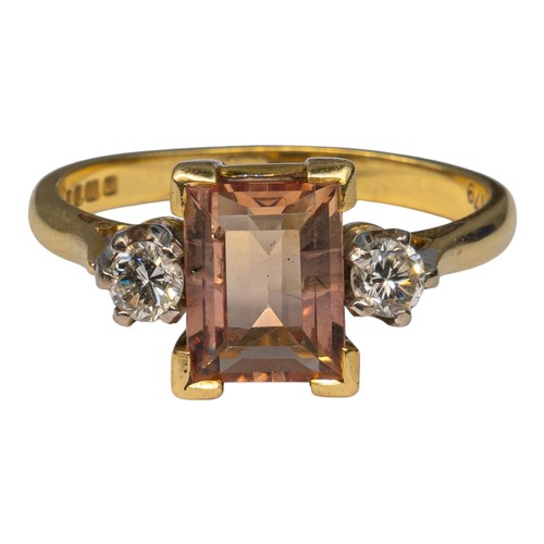 15 - An orangey-pink topaz and brilliant-cut diamond three-stone ringThe rectangular-cut central stone we... 