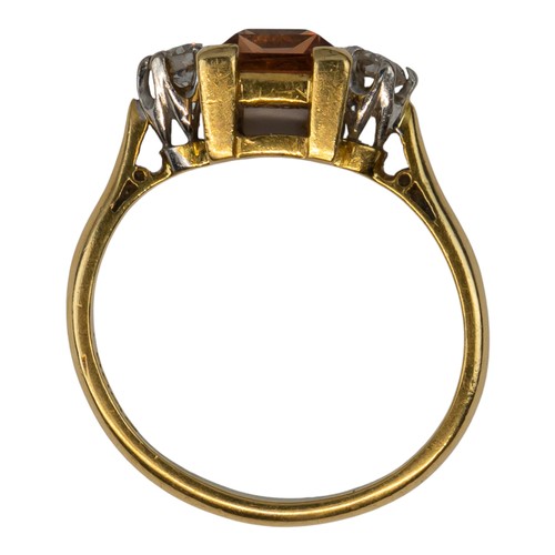 15 - An orangey-pink topaz and brilliant-cut diamond three-stone ringThe rectangular-cut central stone we... 