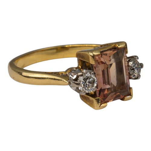 15 - An orangey-pink topaz and brilliant-cut diamond three-stone ringThe rectangular-cut central stone we... 