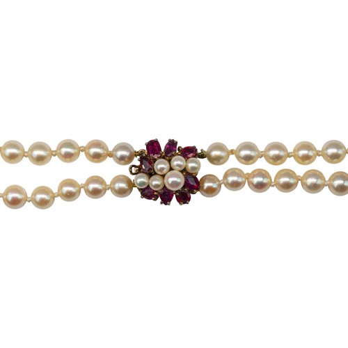 63 - A two-row graduated cultured pearl necklace, with a ruby and pearl clasp, circa 1960The two-row grad... 