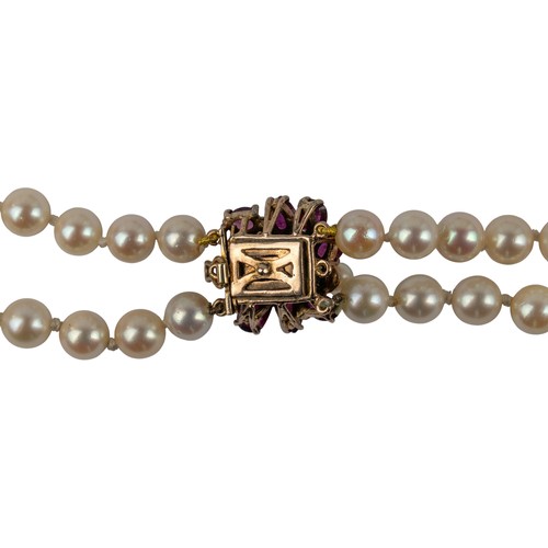63 - A two-row graduated cultured pearl necklace, with a ruby and pearl clasp, circa 1960The two-row grad... 