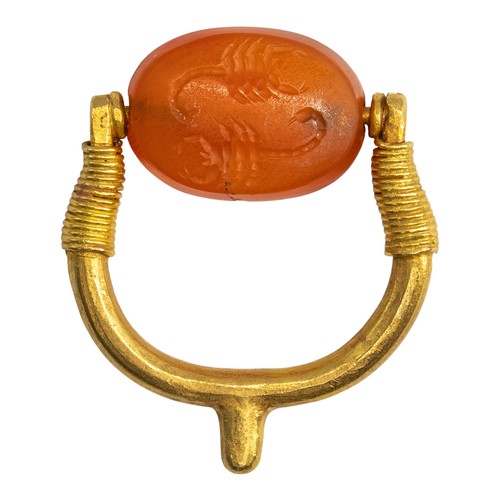 76 - Romano-EgyptianA scaraboid carnelian intaglio ring depicting two scorpions. Set in a yellow gold spu... 