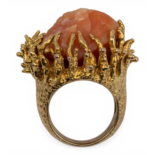 21 - A yellow metal and crystal-set dress ring, circa 1960sThe natural orange-coloured agate crystal set ... 