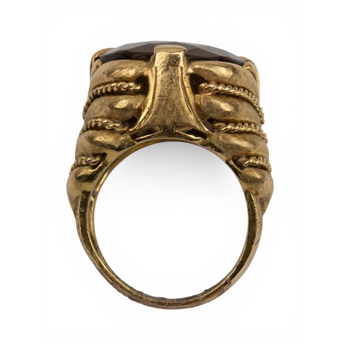 25 - A citrine and 18ct gold dress ring, circa 1960sThe stone set to a feathered-style textured gold and ... 