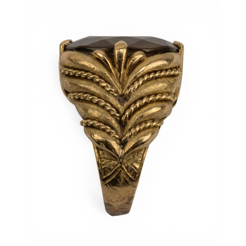 25 - A citrine and 18ct gold dress ring, circa 1960sThe stone set to a feathered-style textured gold and ... 