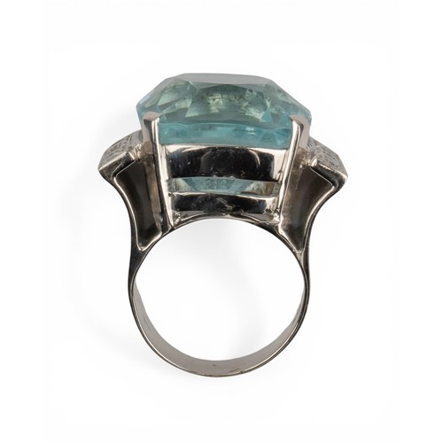 43 - An impressive aquamarine and diamond dress ring, circa 1970The central cushion-shaped aquamarine of ... 