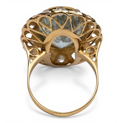 44 - An aquamarine and diamond cluster ring, circa 1960The oval-shaped mixed-cut aquamarine, weighing app... 