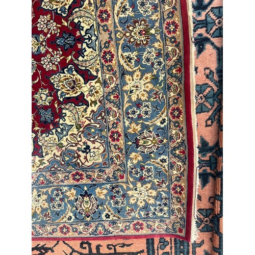An Isfahan rug A deep raspberry field with palmettes and strolling ...