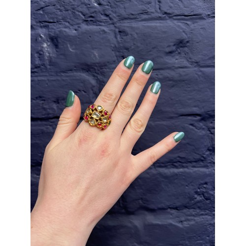 31 - IndianLate 19th CenturyA high carat gold gem set ringThe wide band set with cabochon rubies, emerald... 