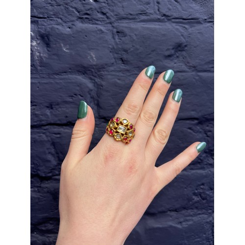 31 - IndianLate 19th CenturyA high carat gold gem set ringThe wide band set with cabochon rubies, emerald... 