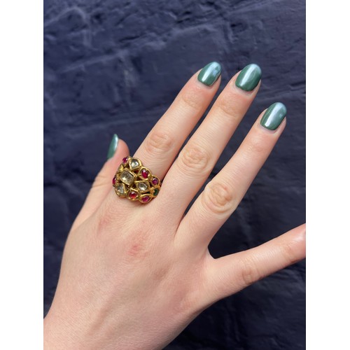 31 - IndianLate 19th CenturyA high carat gold gem set ringThe wide band set with cabochon rubies, emerald... 
