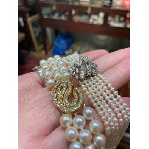 56 - A diamond and six-row cultured pearl choker necklaceThe cluster clasp set with pear-shaped marquise ... 