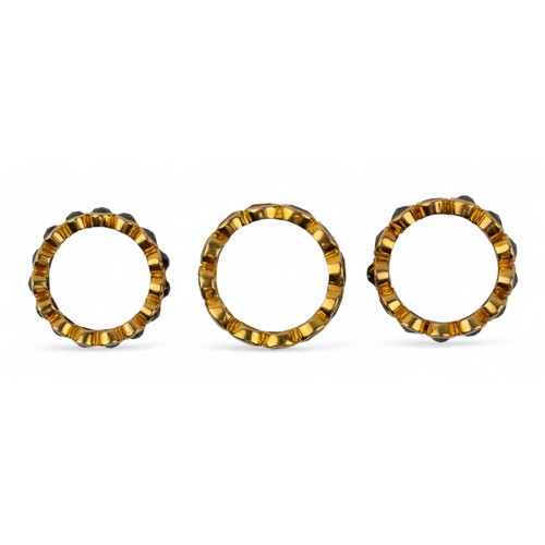1 - Three yellow gold diamond and gem-set band ringsComposed of two rose-cut black diamond band rings mo... 