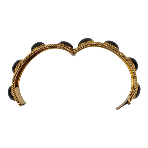 7 - Antique, An impressive cabochon garnet and gold bangle, circa 1870The Etruscan-style bloomed gold wi... 