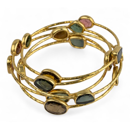 15 - Five yellow gold and gem-set banglesEach yellow gold hoop set with native-cut garnet, tourmaline, am... 