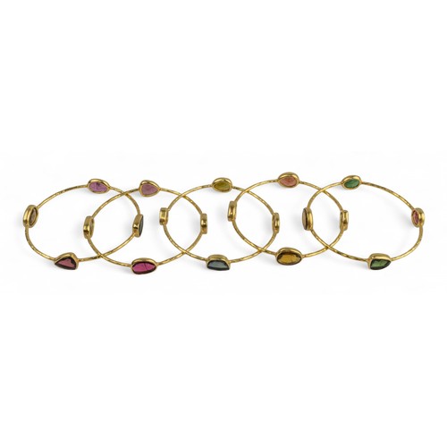 15 - Five yellow gold and gem-set banglesEach yellow gold hoop set with native-cut garnet, tourmaline, am... 