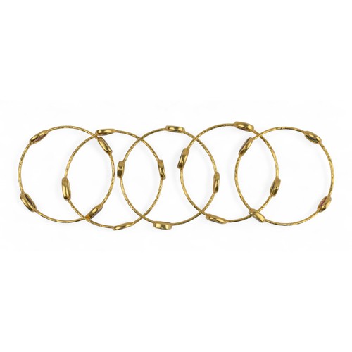 15 - Five yellow gold and gem-set banglesEach yellow gold hoop set with native-cut garnet, tourmaline, am... 