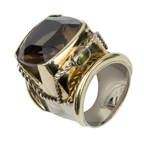 17 - A striking smoky quartz, peridot and gold dress ringThe central cushion-shaped mixed-cut brownish qu... 
