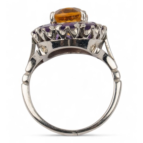 37 - A white gold amethyst and citrine cluster ringThe oval cluster mixed-cut citrine within a surround o... 