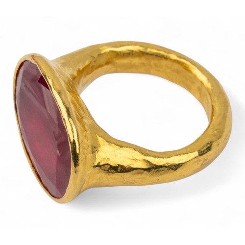 58 - A ruby and high-carat yellow gold dress ringThe top inset wit a large oval-shaped treated ruby. With... 