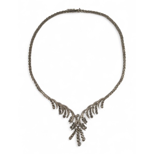 60 - Circa 1960s, A diamond necklaceThe scrolled front set with circular and brilliant-cut diamonds. With... 