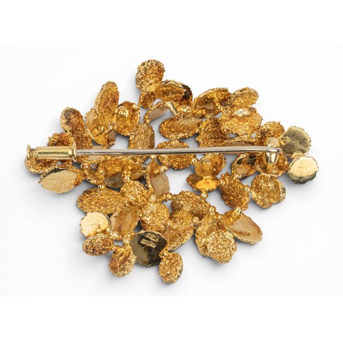 5 - Lotos, An 18ct yellow gold brooch, circa 1970sOf abstract form set with small green brilliant-cut be... 