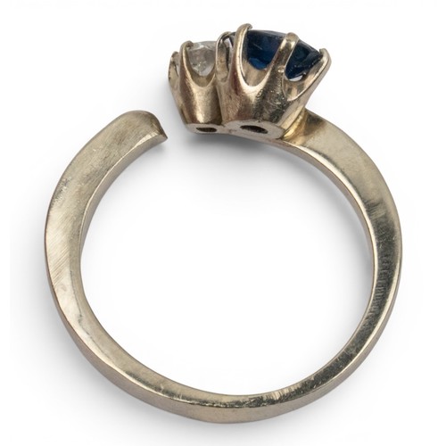 1 - A sapphire and diamond two-stone ringThe oval-shaped mixed-cut sapphire of pretty colour, claw set w... 