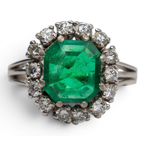 43 - A fine Colombian emerald and diamond cluster ring, circa 1950The octagonal-cut emerald weighing appr... 