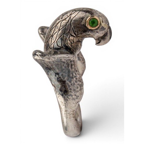 47 - Mosheh Oved, A silver and gold parrot ring, circa 1950The neck modelled and engraved to display plum... 