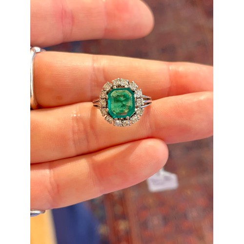43 - A fine Colombian emerald and diamond cluster ring, circa 1950The octagonal-cut emerald weighing appr... 
