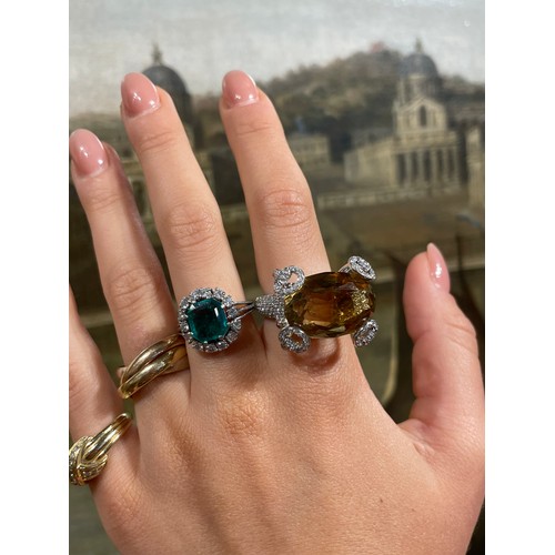 43 - A fine Colombian emerald and diamond cluster ring, circa 1950The octagonal-cut emerald weighing appr... 