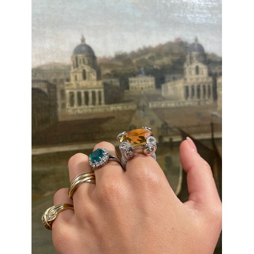 43 - A fine Colombian emerald and diamond cluster ring, circa 1950The octagonal-cut emerald weighing appr... 