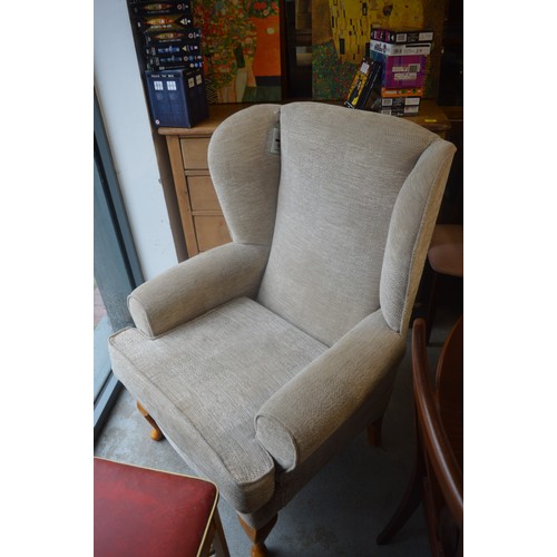 143 - Large Wingback Armchair having Cabriole Front Legs upholstered in a Cream Fabric