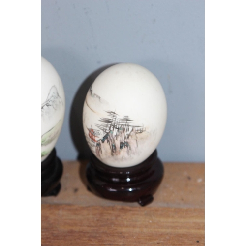 554 - 2 X HAND PAINTED ORIENTAL EGGS ON STANDS