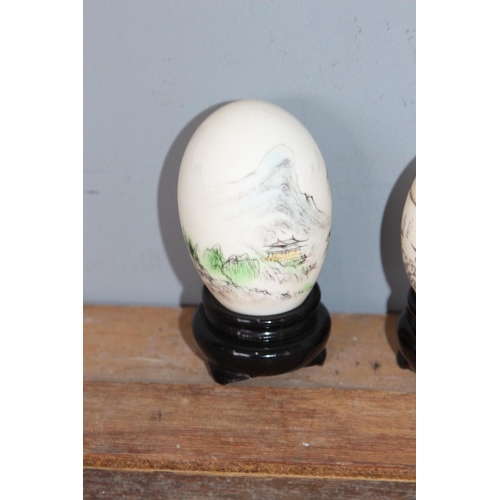 554 - 2 X HAND PAINTED ORIENTAL EGGS ON STANDS