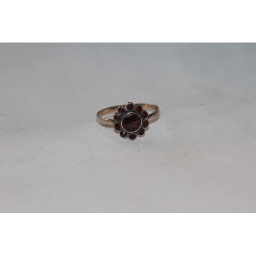 803 - 9CT GOLD GARNET FLORAL CLUSTER RING - 10 SMALL SURROUNDING LARGE GARNET