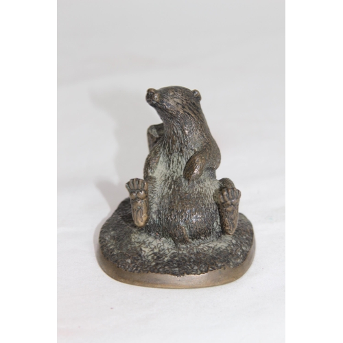 610 - BRONZE MODEL OF A BADGER LEANING AGAIST A TREE TRUNK