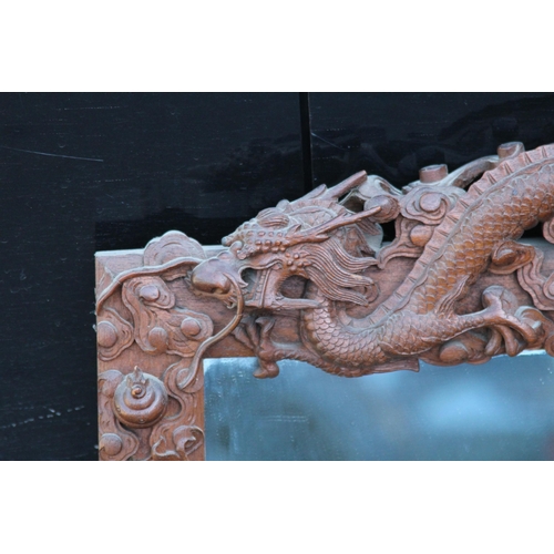 173 - VINTAGE EASTERN WOODEN CARVED MIRROR DEPICTING DRAGONS ETC 
65 X 46CM