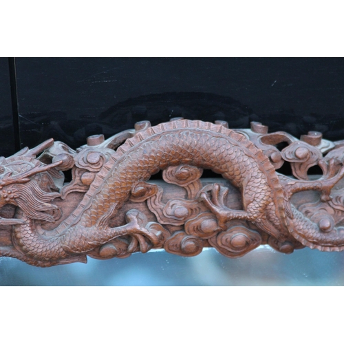 173 - VINTAGE EASTERN WOODEN CARVED MIRROR DEPICTING DRAGONS ETC 
65 X 46CM