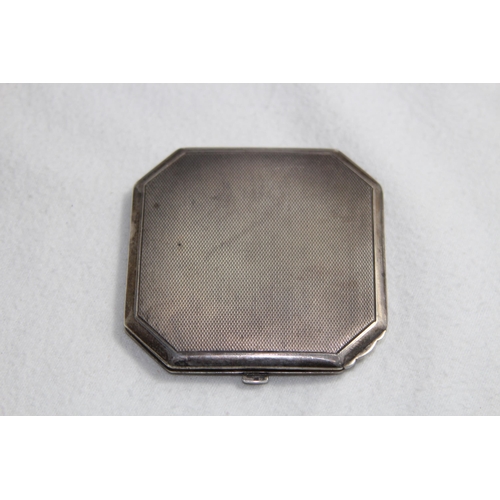 1099 - SILVER COMPACT OF OCTAGONAL FORM - BIRMINGHAM 1951 AND A FLORAL DECORATED WHITE METAL COMPACT