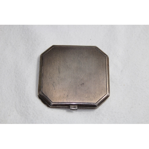 1099 - SILVER COMPACT OF OCTAGONAL FORM - BIRMINGHAM 1951 AND A FLORAL DECORATED WHITE METAL COMPACT